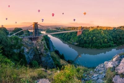 Hot air balloons and bridge over river bend