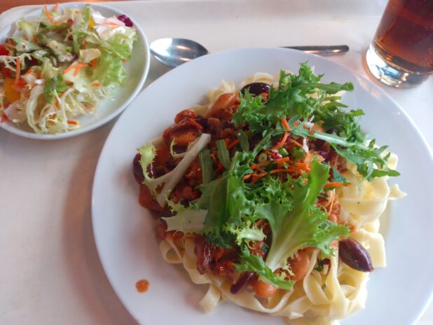 mediterrane auberginen-tomatenpfanne auf tagliatelle mit fetakäse und kleinem gemischten salat