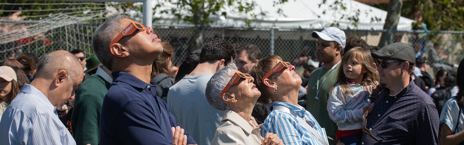 Adults in Caltech glasses looking up at the solar eclipse