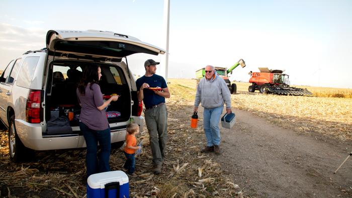 Farm family eating in field.