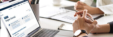 Group of people accessing laptop with the Payer Portal on the screen