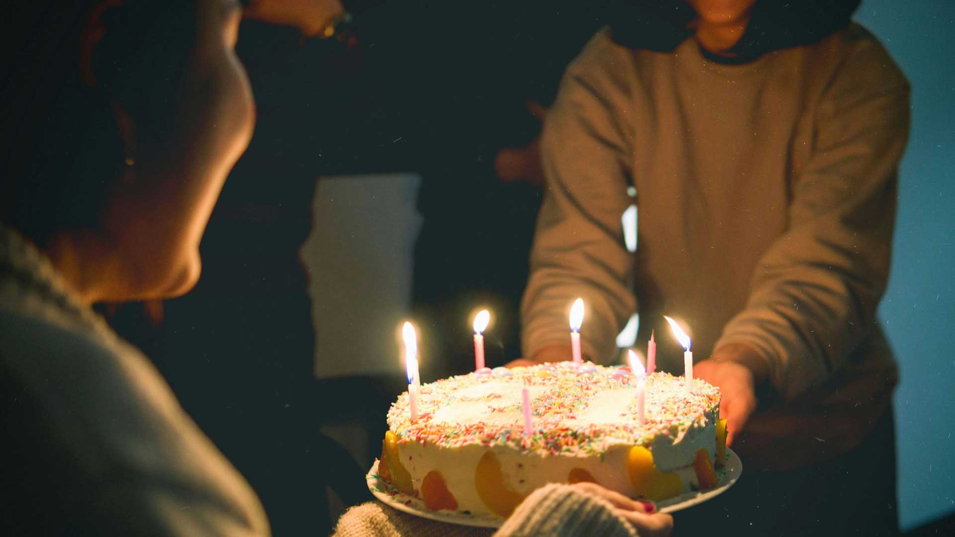 senhoras seguram bolo de aniversário