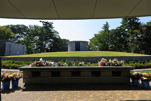 東京都立八柱霊園（千葉県松戸市）に4年前にできた合葬式墓地。合葬式墓地とは、多くの遺骨を一緒に埋葬する形式の墓所を指す。10万体の遺骨を地下に収容できる。円形墳墓になっていて、その前に献花台がある。将来にわたって一族の墓を継承していくことを困難と考えた人が、こうした共同墓に入るケースが増えている。