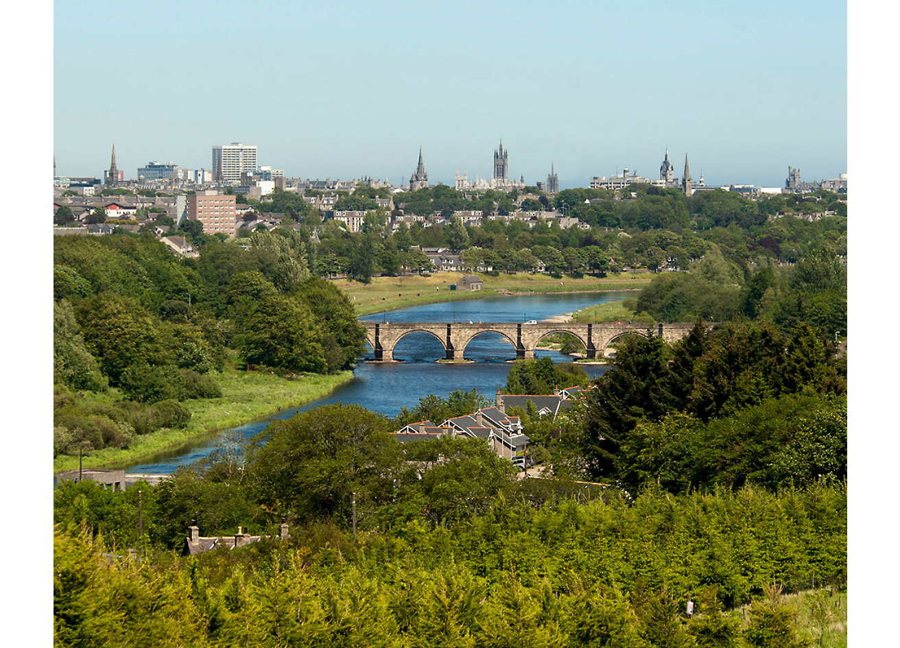 Picture of a city taken from a green lush garden or view