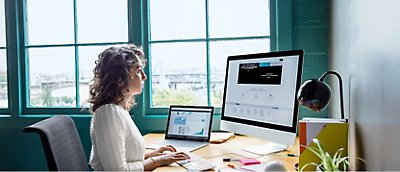 A woman sitting at a desk in front of a window