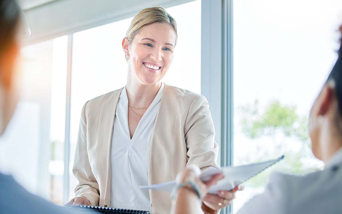 Woman passing a document to a colleague