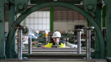 Factory worker examining equipment.