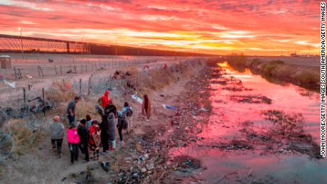 CIUDAD JUAREZ, MEXICO - FEBRUARY 01: Seen from an aerial view, immigrants wait next to razor wire after crossing the Rio Grande into El Paso, Texas on February 01, 2024 from Ciudad Juarez, Mexico. Those who get through the wire are then allowed to proceed for processing by U.S. Border Patrol agents. (Photo by John Moore/Getty Images)