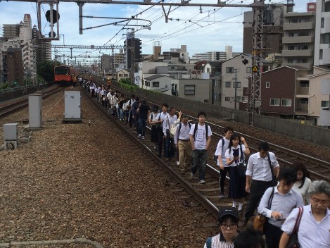 止まった電車から線路を使って移動する乗客＝大阪市福島区で２０１８年６月１８日午前９時１３分、加古信志撮影