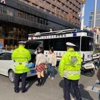 交通違反の取り締まりを行う警察官ら＝北京市内で2024年3月17日午後3時26分、岡崎英遠撮影