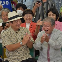 当選確実となり、喜びの表情を見せる共産党の赤嶺政賢氏（右）＝那覇市で2024年10月27日午後11時22分、日向米華撮影