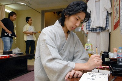 楽屋で根多（ねた）帳に演目を書き込む桂三四郎さん。「大阪で育てられ、鍛えてもらいました」＝大阪市北区の天満天神繁昌亭で2007年8月、大橋公一撮影