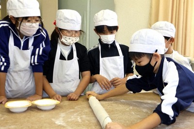 そば打ち体験で生地を伸ばす上豊富小学校の子どもたち＝福知山市畑中の農村婦人の家上豊富会館で、庭田学撮影