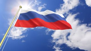 The Russian flag with the sun shining in the background.