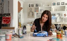 woman painting toy car