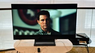 Samsung S90D 48-inch TV on a marble table with Top Gun Maverick playing on screen