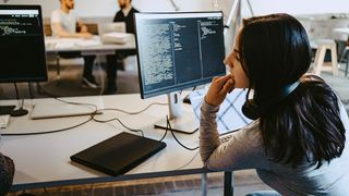 A young woman and a colleague study on one of the best online coding courses