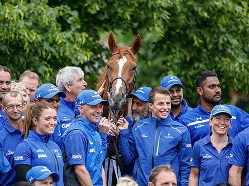 Derek Poupard standing next to a racehorse that won a race while wearing a 3D pad.