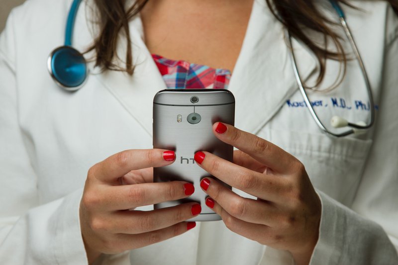 This image shows a doctor using WhatsApp for communication with patients