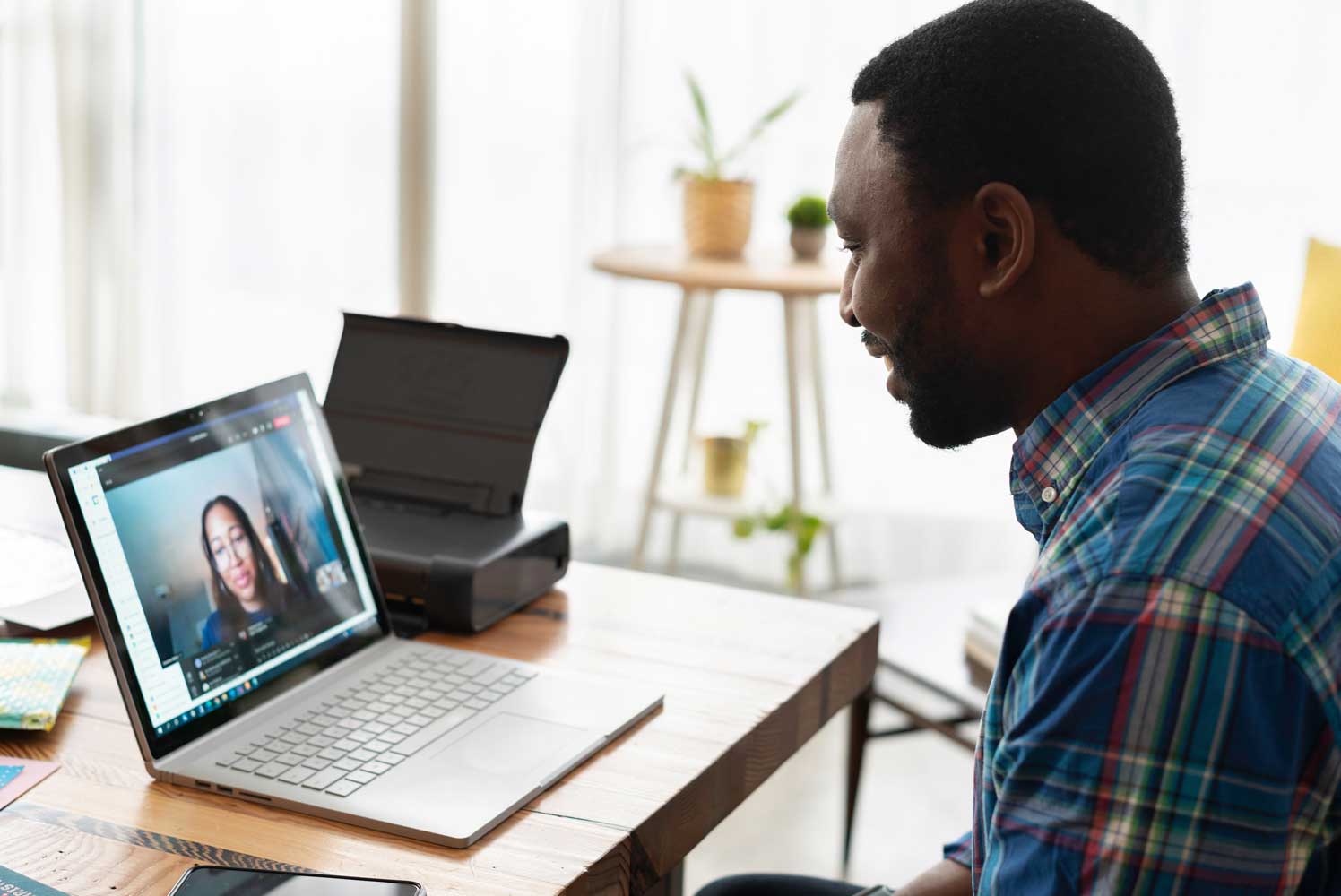 Image of a man with black hair and beard having a video call with a woman who has black hair