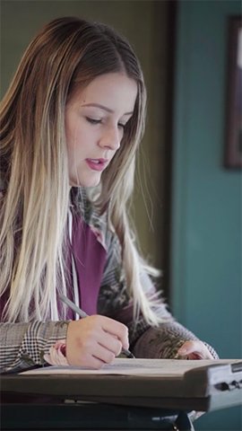 Jessica Wegman sitting at a desk, taking notes.