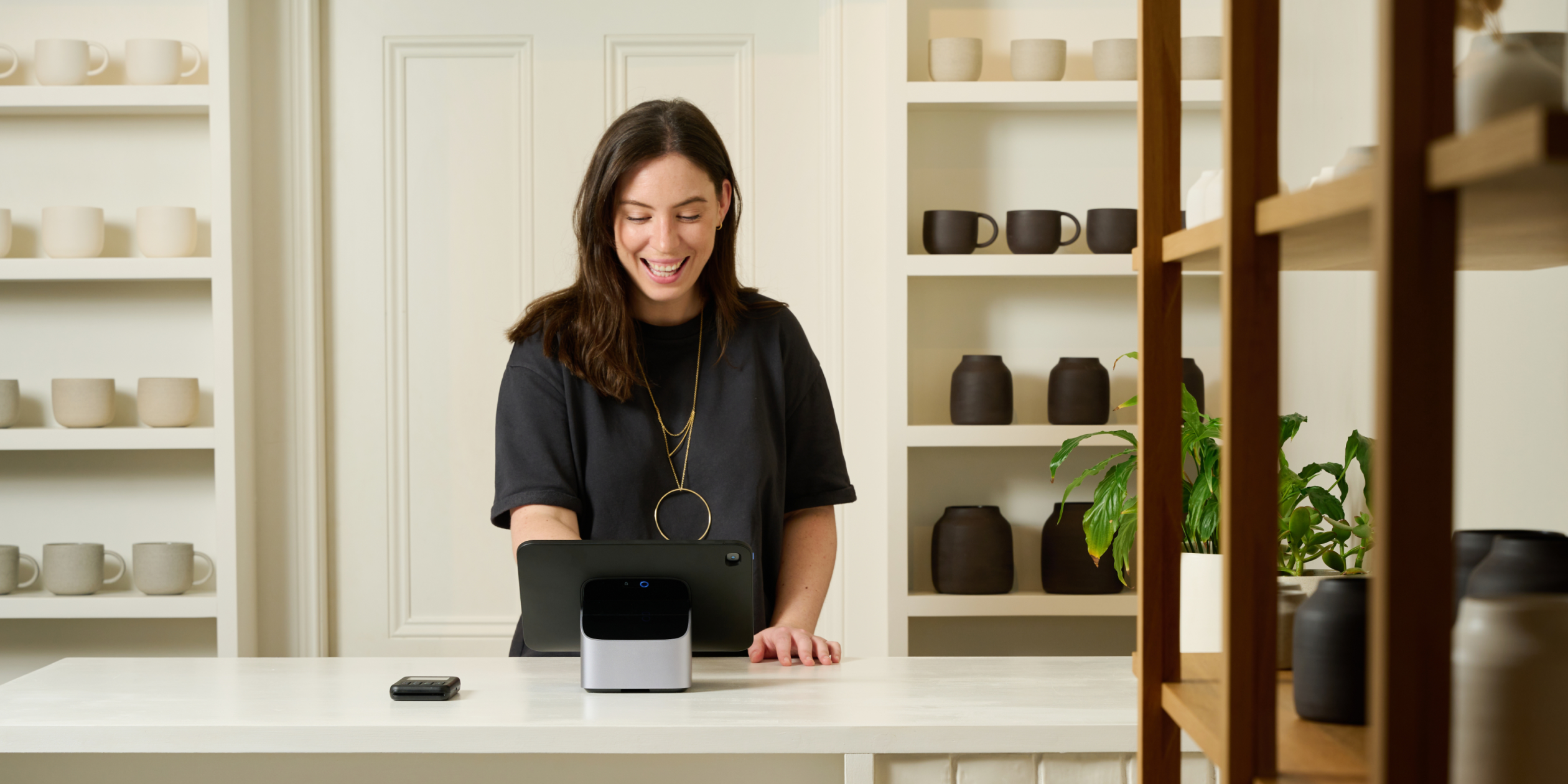 POS hardware from Shopify's Retail Collection is displayed on a retail counter. It includes POS Terminal and Tablet Stand. Tablet is sold separately.