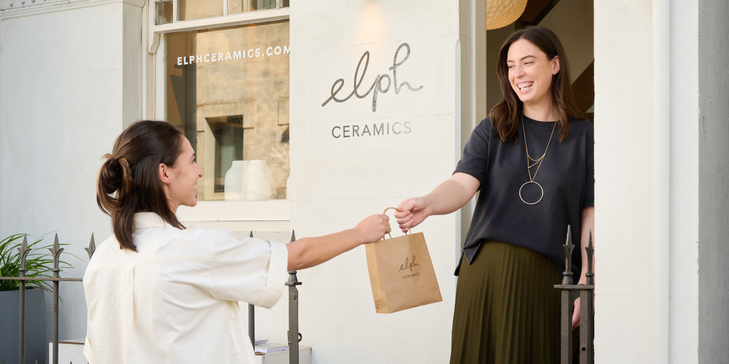 Deux membres du personnel commercial servent les clients en caisse à l’aide du matériel Shopify PDV. L’un utilise le système de comptoir pour le paiement tandis que l’autre traite un retrait en magasin sur POS Go.