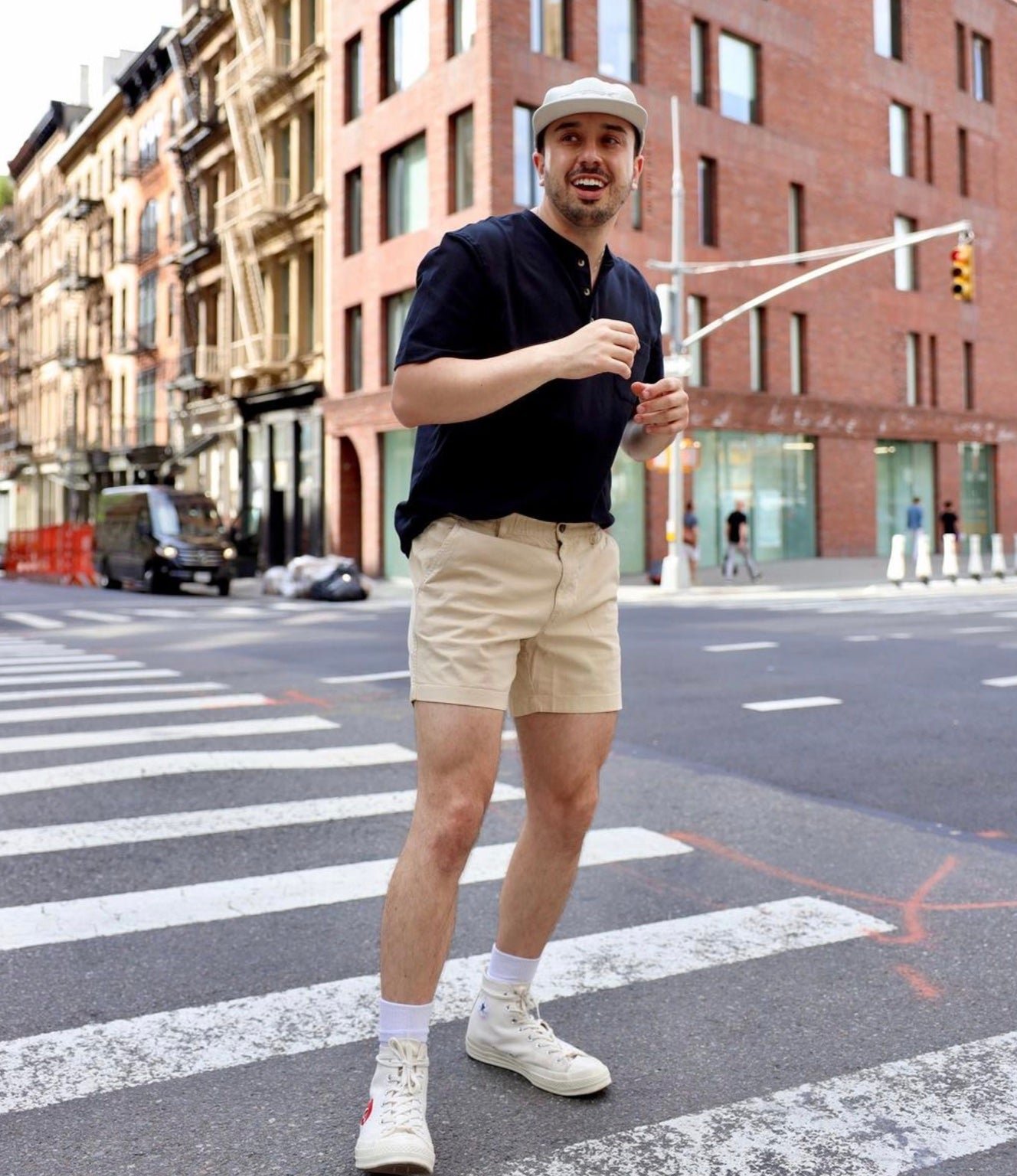 Man standing in a crosswalk in New York City in Bearbottom Clothing shorts and a shirt.