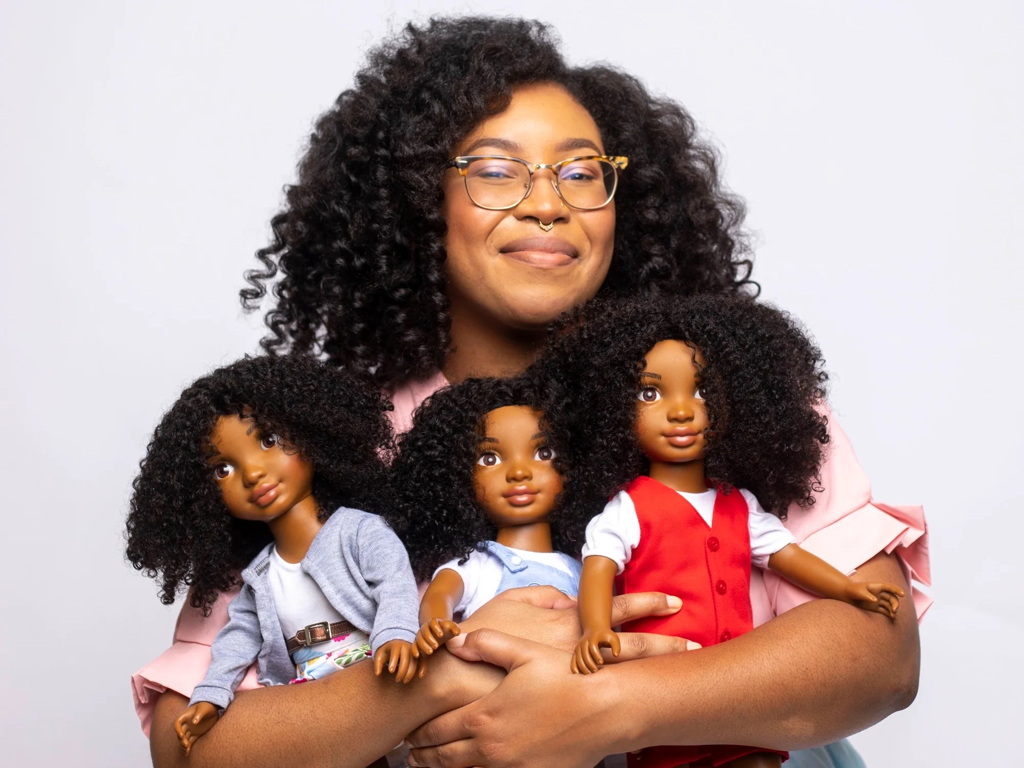 Portrait of entrepreneur Yelitsa Jean-Charles holding her products Healthy Roots Dolls