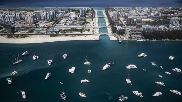  An aerial shot of a city with beaches and yachts moored offshore