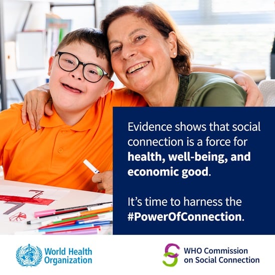 An older teacher with her arms around a younger boy living with Down Syndrome, both smiling while drawing. Caption: 'Evidence shows that social connection is a force for health, well-being, and economic good. It's time to harness the #PowerOfConnection.'