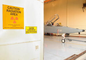 Nondestructive testing an airplane with X rays in a lead-lined hangar.