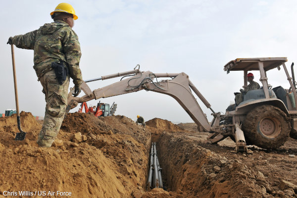 An excavator digs a trench for a fiber optic cable.