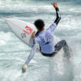 Surfer in white rash vest doing 360 degree spin