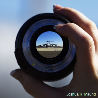 A Globemaster airplane seen, in reduced form, through a camera lens