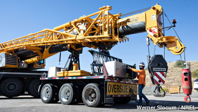 A yellow Liebherr truck crane, preparing to start work, seen from the very rear