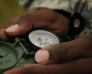 Hands holding a magnetic compass.