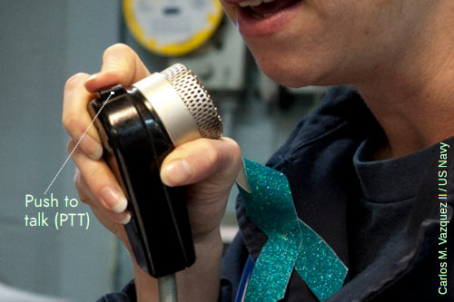 US Navy sailor talking into an intercom.