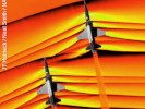 Orange Schlieren photograph of two supersonic jets flying upward