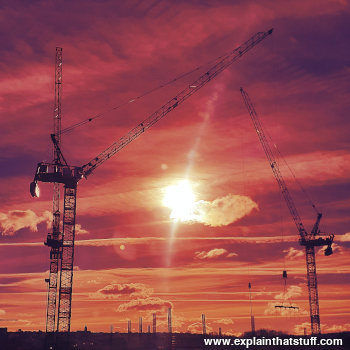 Tower cranes against a red sunset in Bristol, England, 2024.