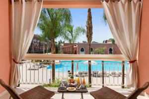 a view of the pool from the living room of a resort at Savoy Le Grand Hotel Marrakech in Marrakesh