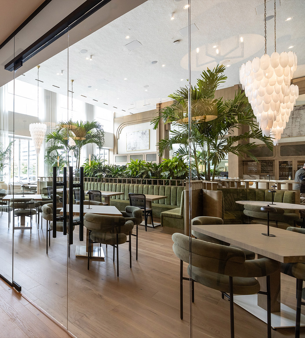 a restaurant with tables, booths, chairs and chandeliers and glass doors