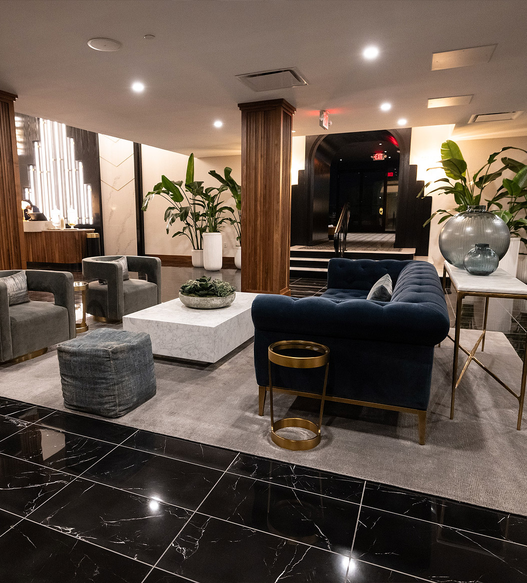 a lobby with a couch, chairs and a table