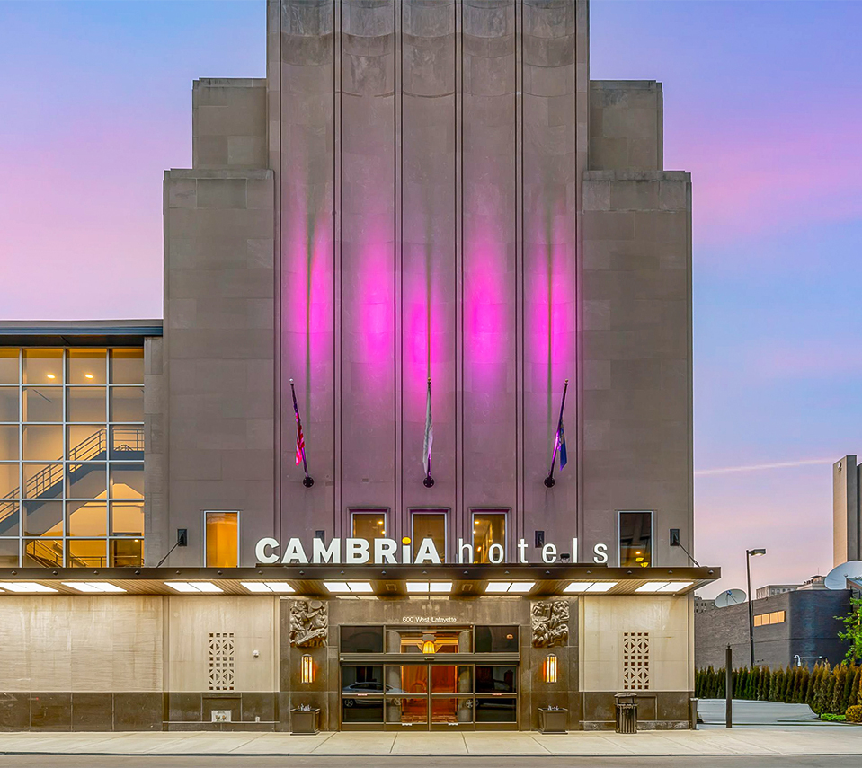 a white building with pink lights shining on it