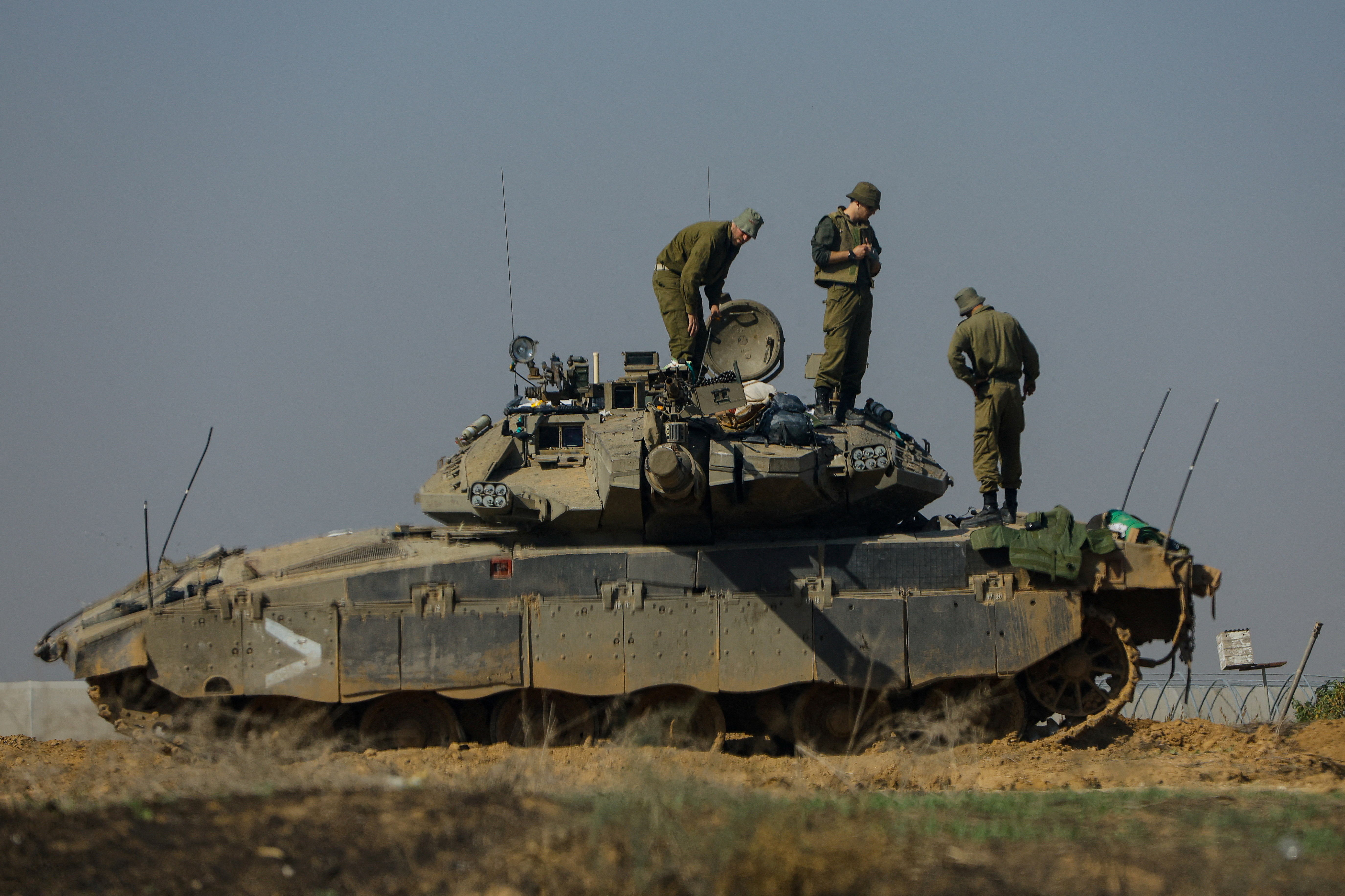 Israeli soldiers work on a tank near the border with Gaza, amid the ongoing conflict between Israel and the Palestinian Islamist group Hamas
