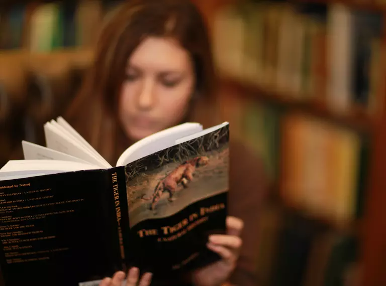 student_fellow_reading_a_book_in_library