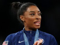 PARIS, FRANCE - JULY 30: Gold medalist Simone Biles of Team United States celebrates on the podium during the medal ceremony for the Artistic Gymnastics Women's Team Final on day four of the Olympic Games Paris 2024 at Bercy Arena on July 30, 2024 in Paris, France. (Photo by Naomi Baker/Getty Images)