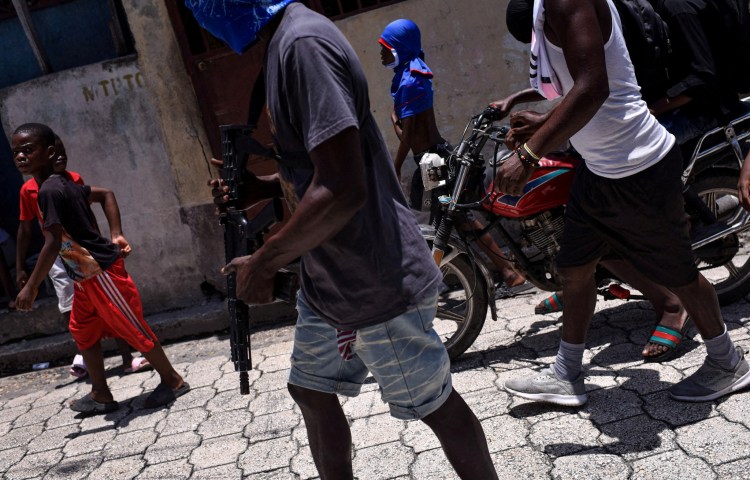 Children accompany armed gang members in a march organised by former police officer Jimmy "Barbecue" Cherizier, leader of an alliance of armed groups, in the Delmas neighbourhood, in Port-au-Prince, Haiti, May 10, 2024. Nearly half of the country's population is struggling to feed themselves due to the conflict, since the 2021 assassination of Haiti's last president, armed gangs have expanded their power and influence, taking over most of the capital and expanding to nearby farmlands. "If you are displaced or your family doesn't have a place to sleep, you may need to join armed groups just to cover your needs," said Save the Children Haiti food advisor Jules Roberto. REUTERS/Pedro Valtierra Anza SEARCH "ARDUENGO VALTIERRA HAITI HUNGER" FOR THIS STORY. SEARCH "WIDER IMAGE" FOR ALL STORIES. TPX IMAGES OF THE DAY - RC2RN8AJCNUV