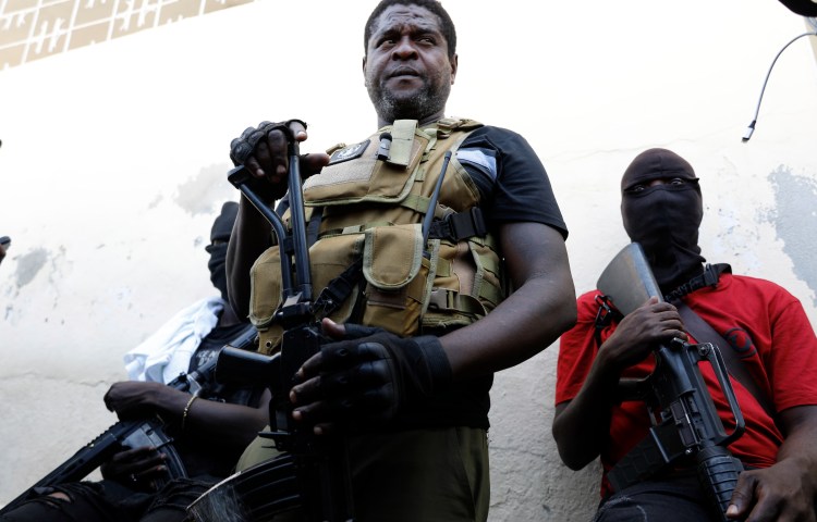 Jimmy Chérizier, a former elite police officer who now runs a gang federation, stands with his gang members in Port-au-Prince, Haiti, in March 2024.