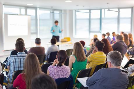 Teachers at a conference listening to a talk